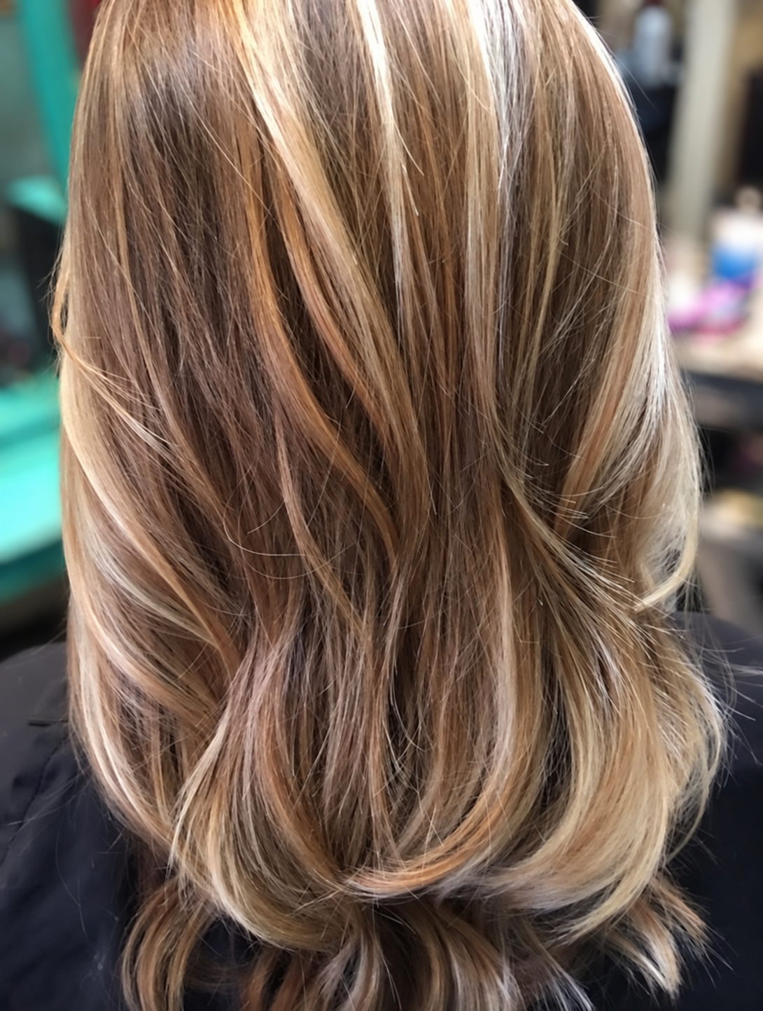 Soft layers with blonde highlights over a darker base, styled by Kellie